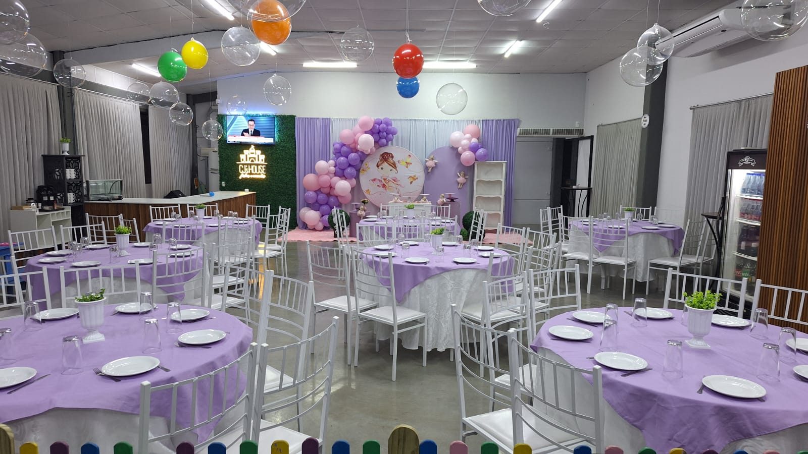 Salão Disney preparado para festa infantil, com mesas lilás e decoração temática