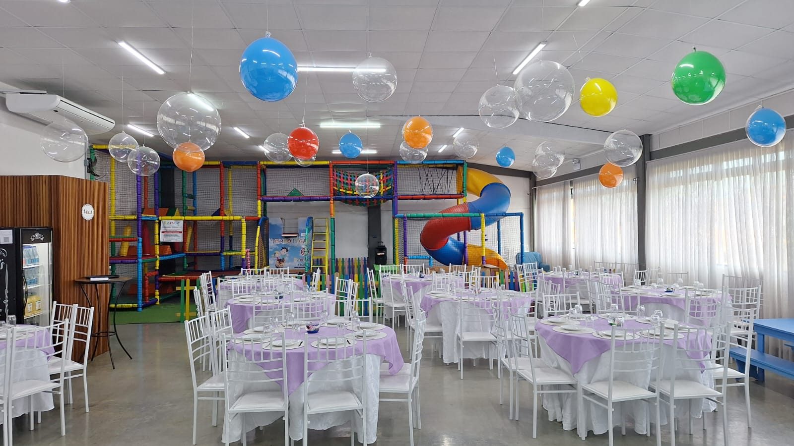 Salão Disney com playground colorido e mesas decoradas