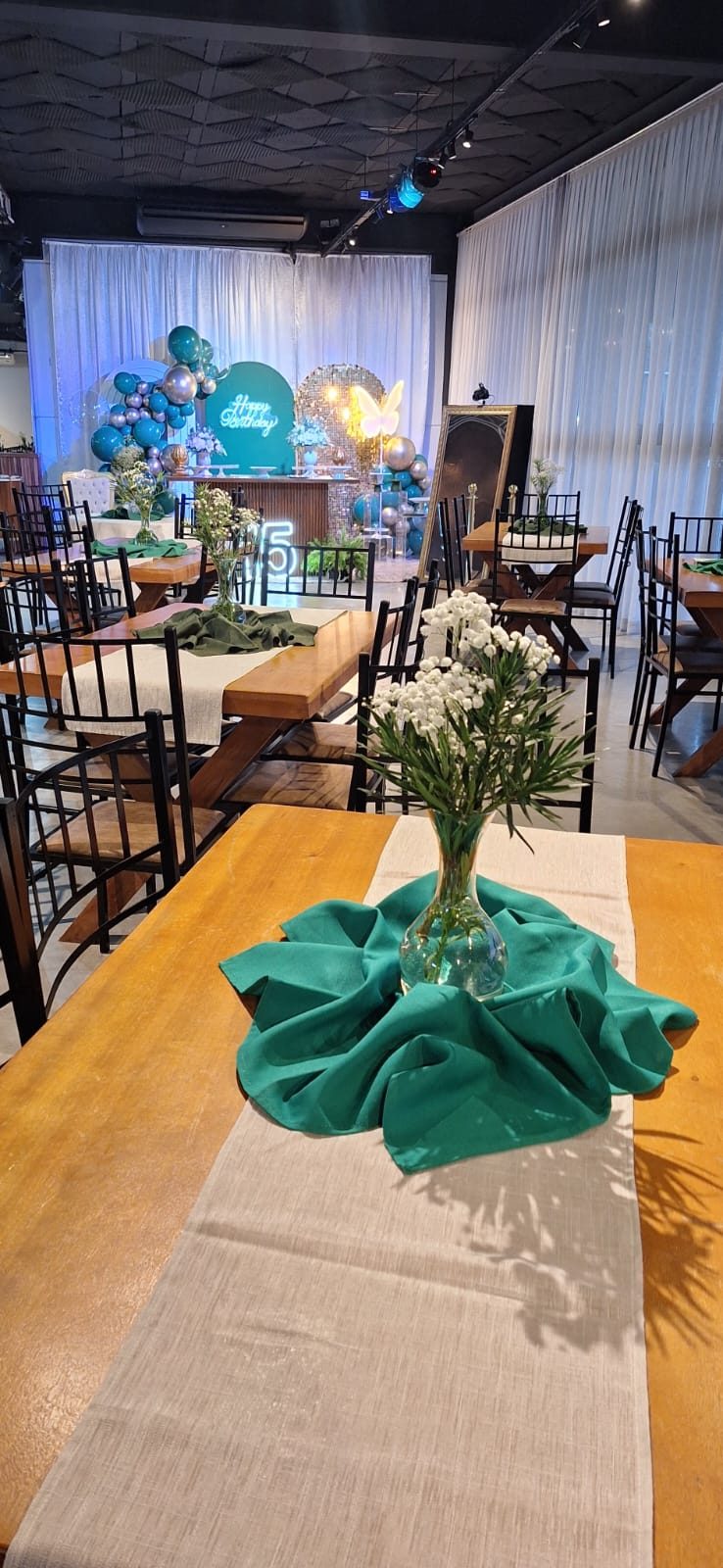 Mesa posta com arranjo de flores e guardanapo verde no Salão Las Vegas